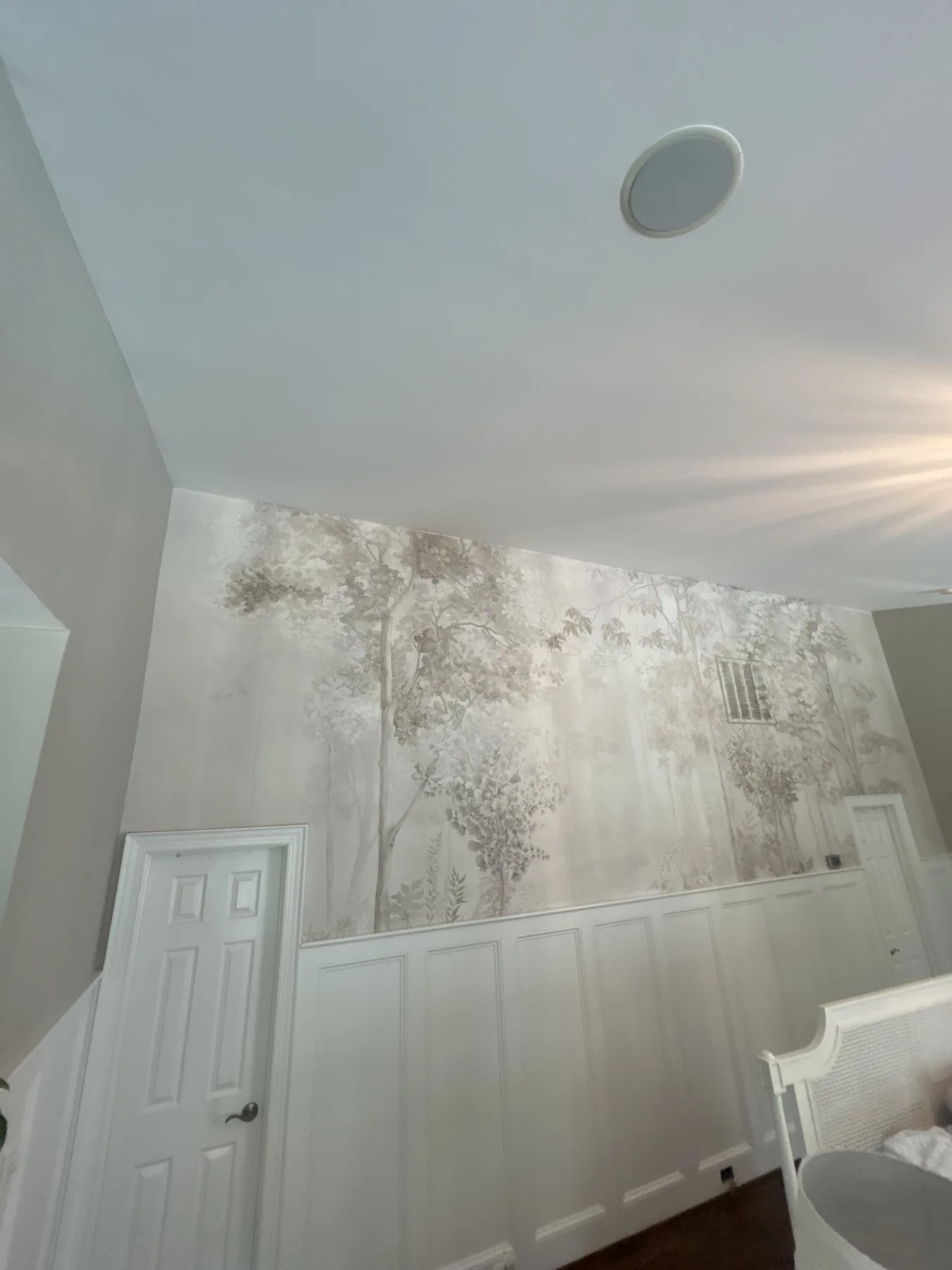 15-foot high double height ceiling misty forest scenic mural installation above wainscoting