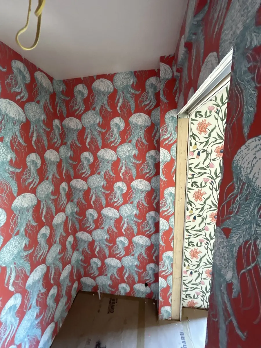 Coral red jellyfish print wallpaper in a small dressing room — wallpaper installation by ProKir Design, serving Manhattan