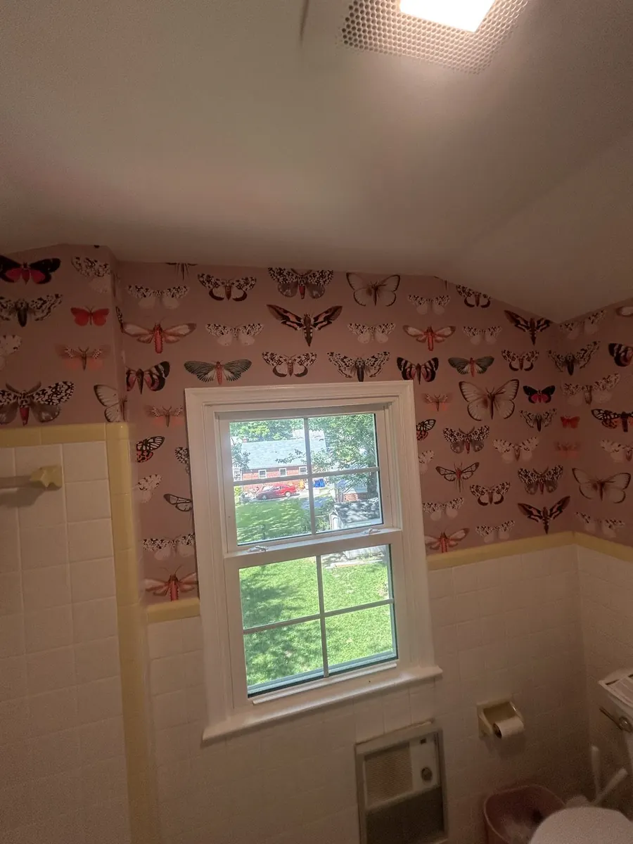 Pink moth print wallpaper above a vintage tiled bathroom — wallpaper installation by ProKir Design, serving Westchester County