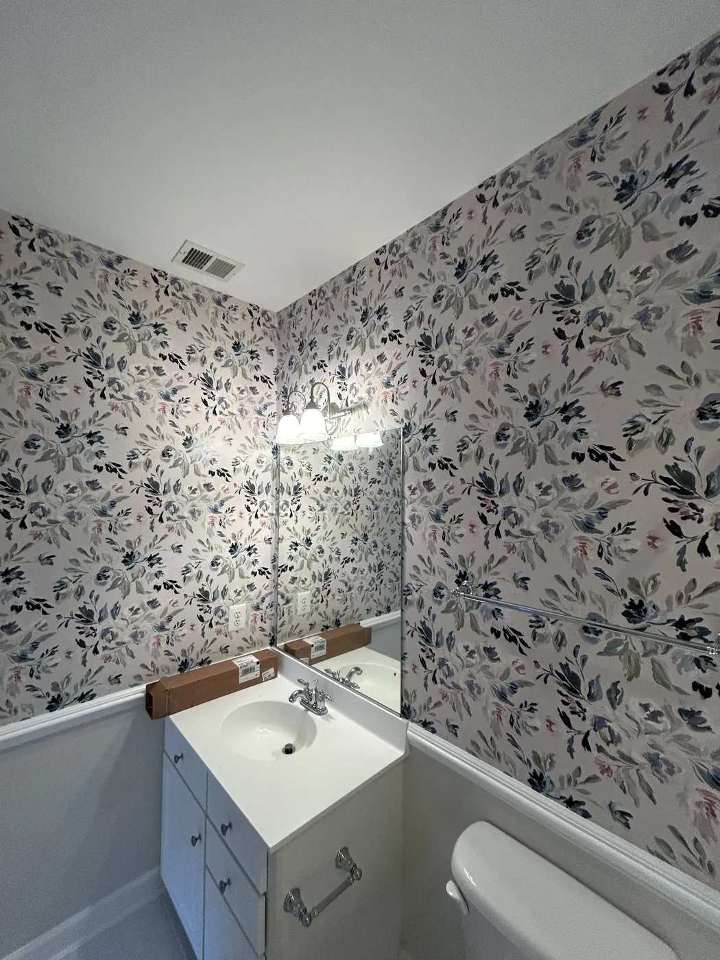 Watercolor leaf wallpaper above wainscoting in a bathroom — wallpaper installation by ProKir Design
