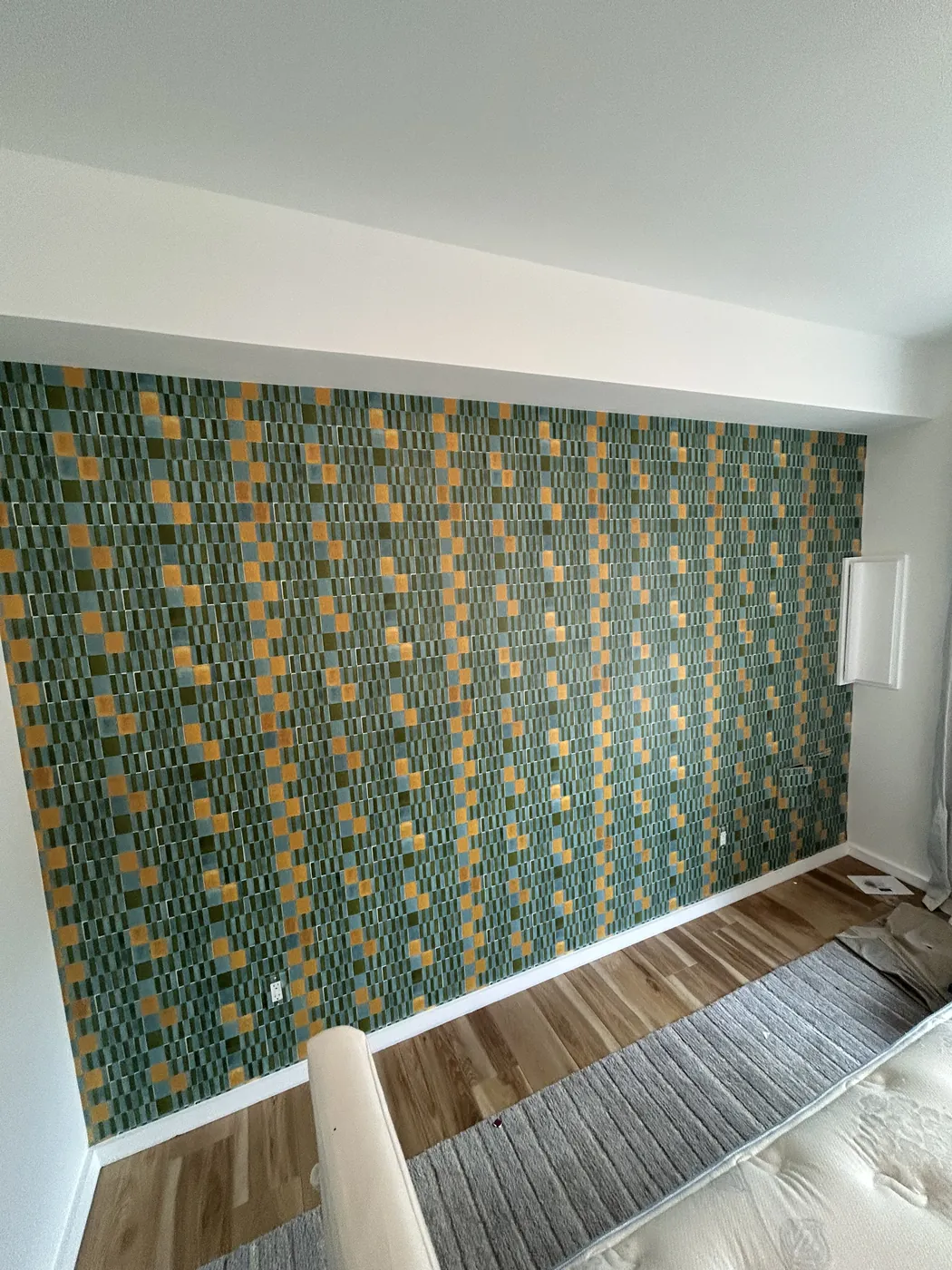 Green and gold geometric accent wall in a bedroom — wallpaper installation by ProKir Design