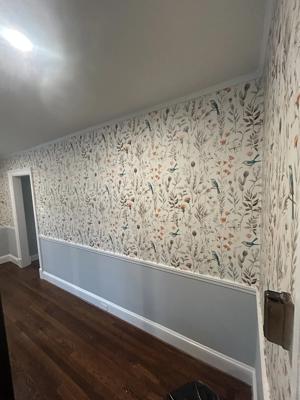 Botanical wallpaper above a chair rail in a dining room — wallpaper installation by ProKir Design