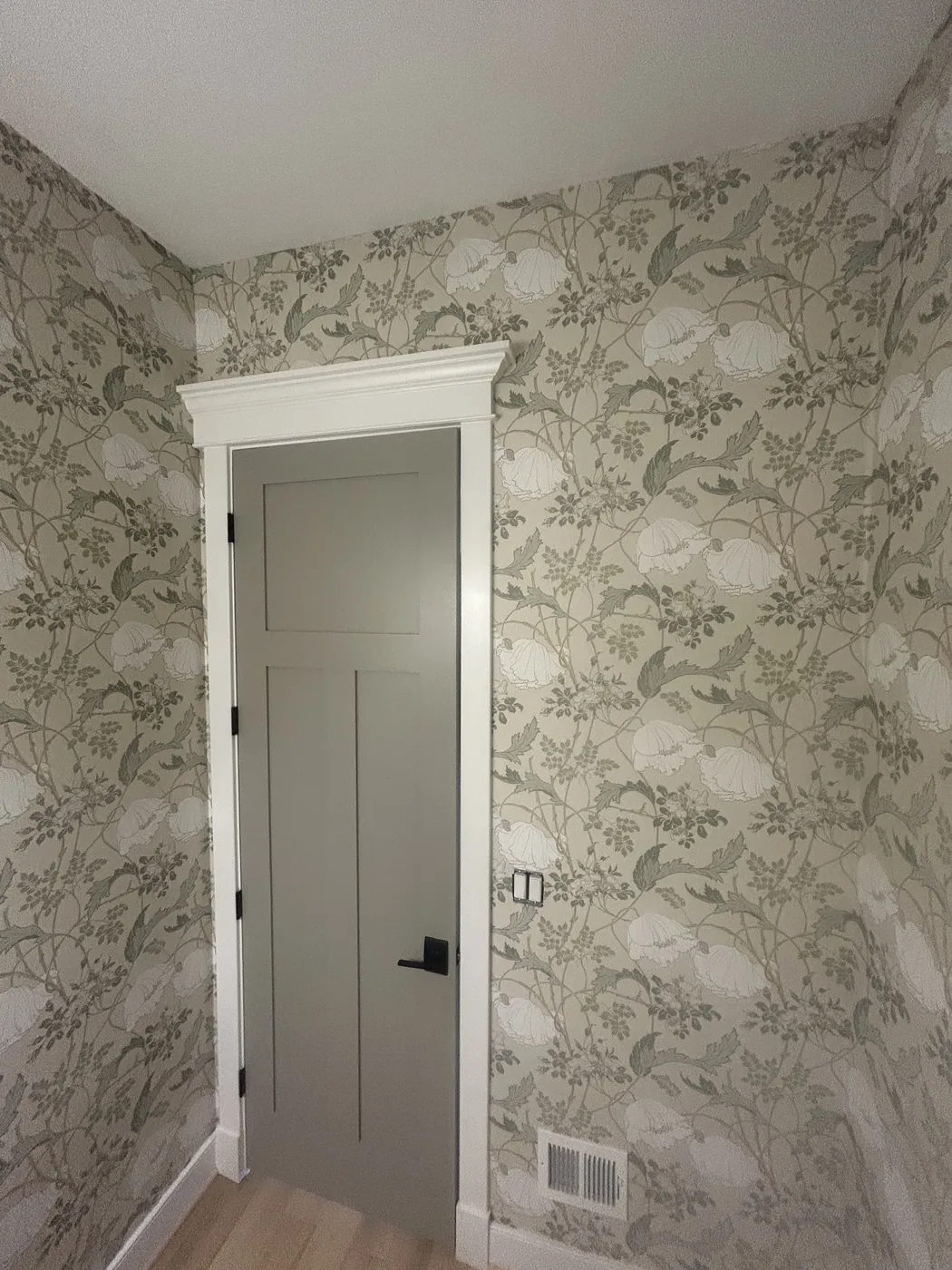 Sage floral wallpaper around a hallway door — wallpaper installation by ProKir Design
