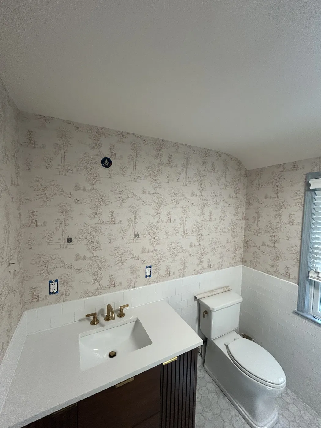 Soft neutral toile wallpaper above wainscoting in a bathroom — wallpaper installation by ProKir Design