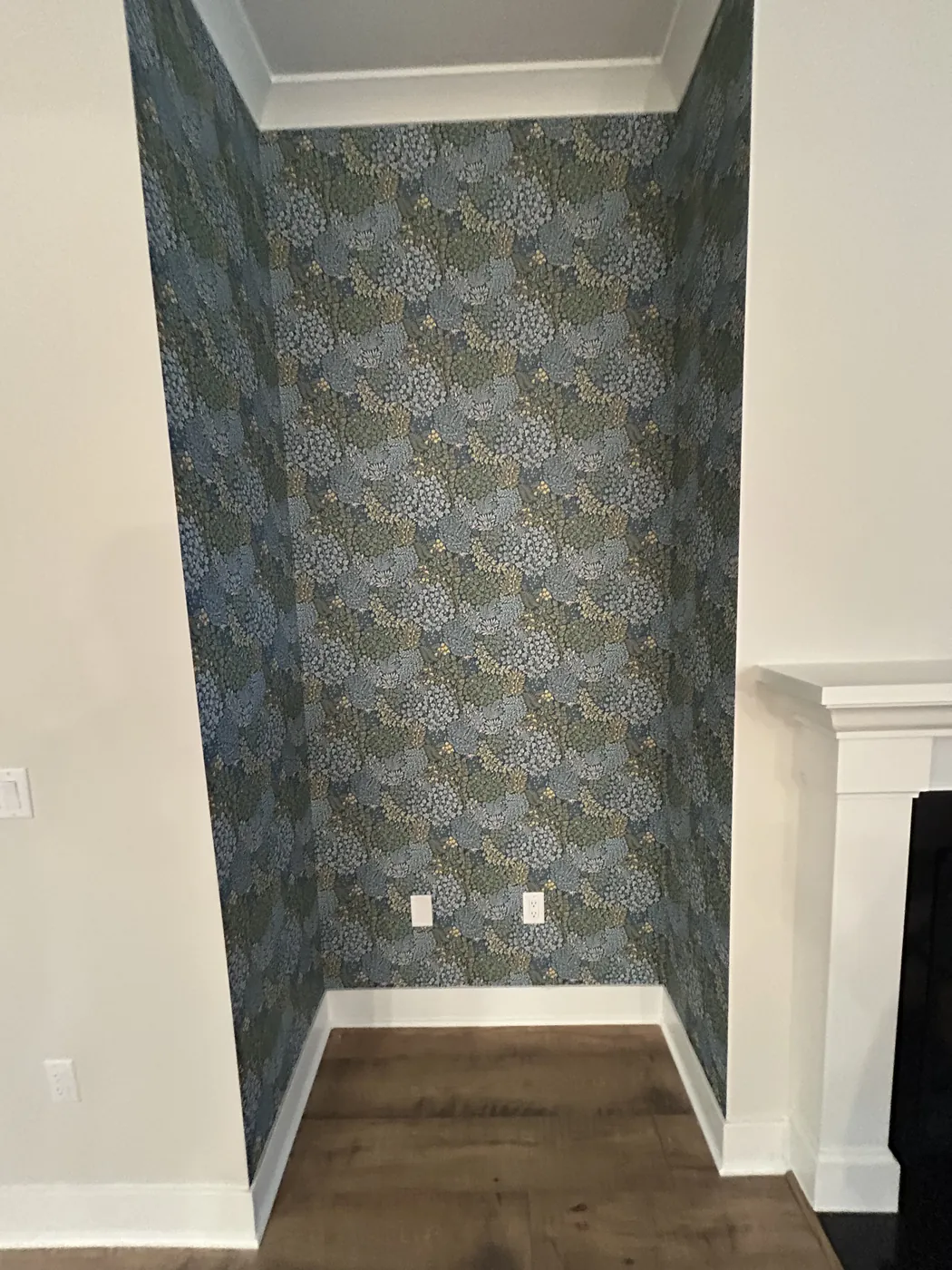 Leafy botanical wallpaper in an alcove beside a fireplace — wallpaper installation by ProKir Design