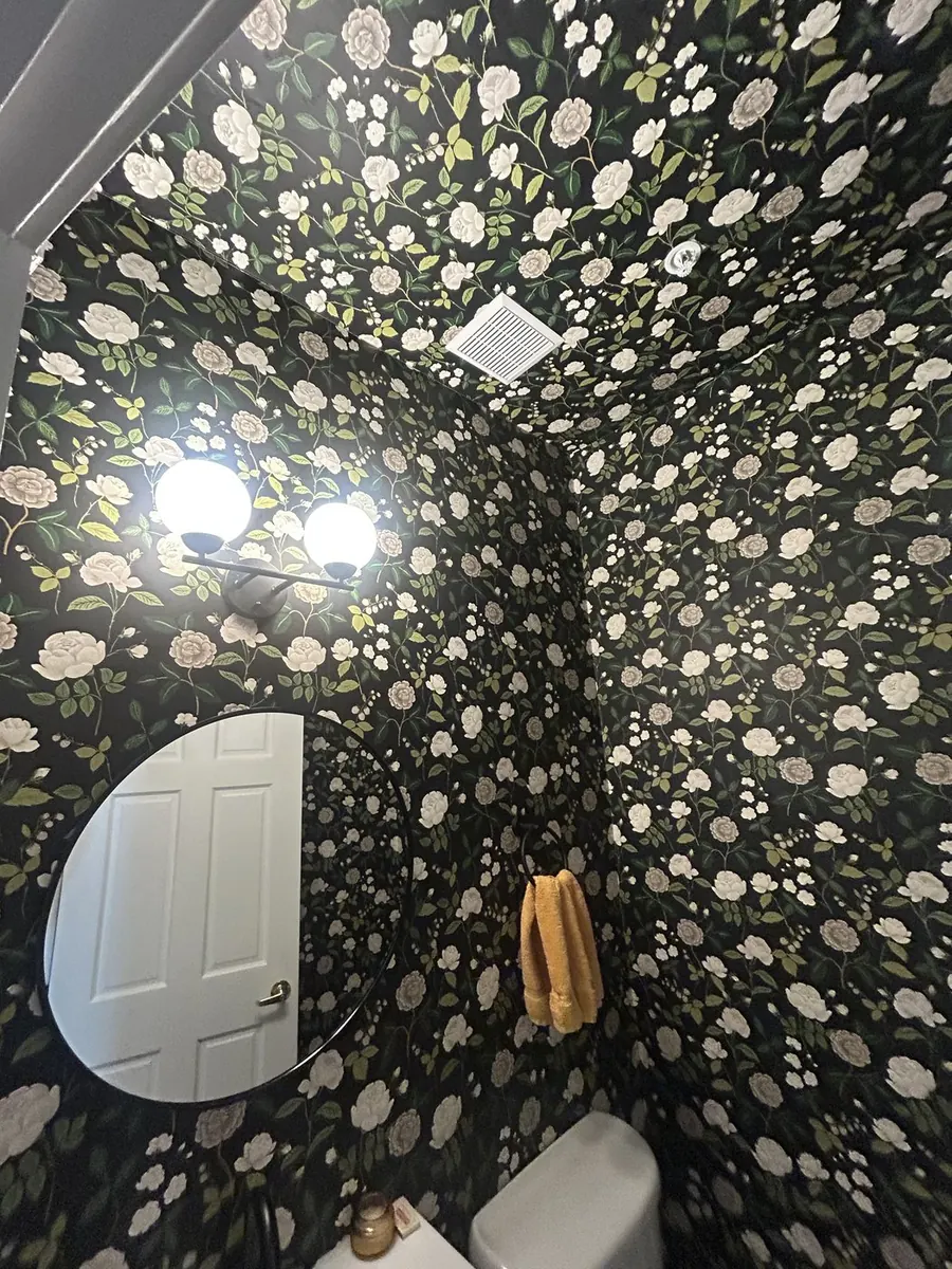 Designer vanity installation with graphic monochrome botanical wallpaper and round illuminated mirror — ProKir Design NYC