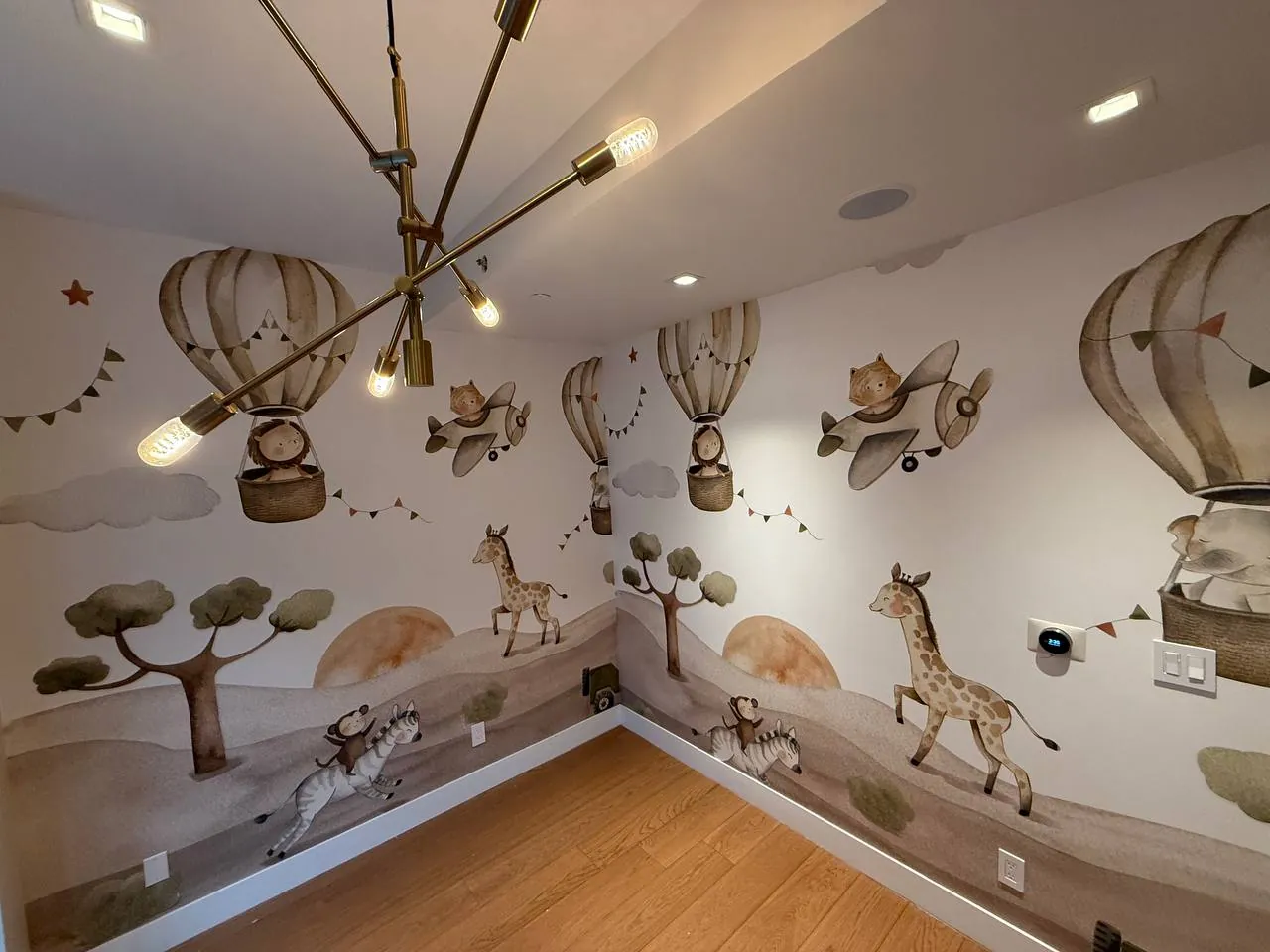 Hot air balloon and animal mural in a nursery — wallpaper installation by ProKir Design