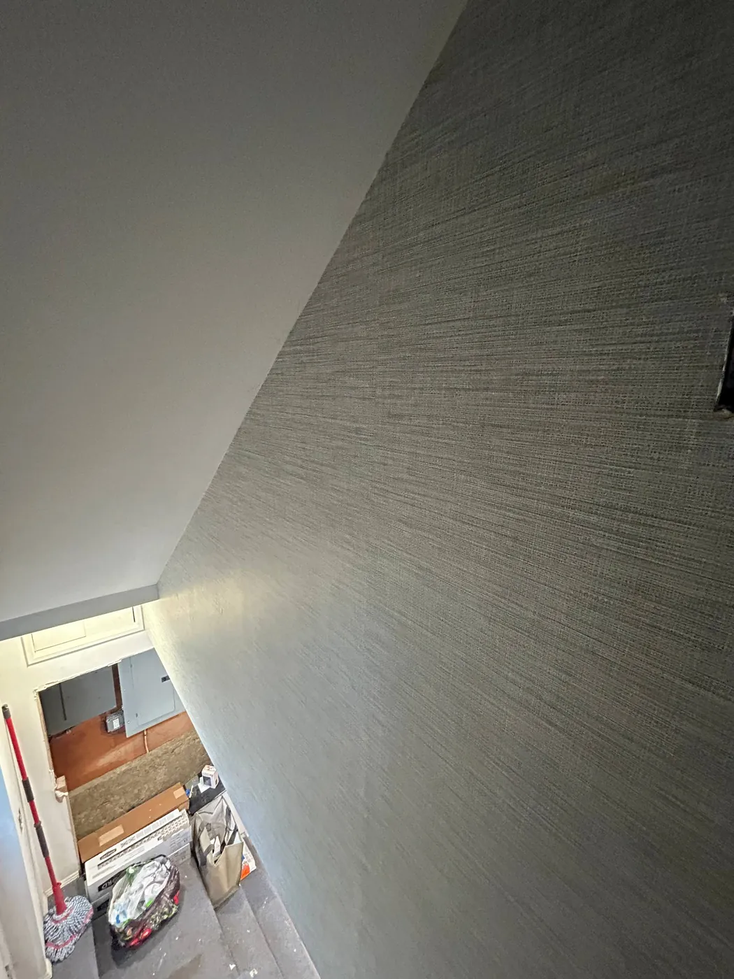 Grey grasscloth on a tall hallway wall — wallpaper installation by ProKir Design