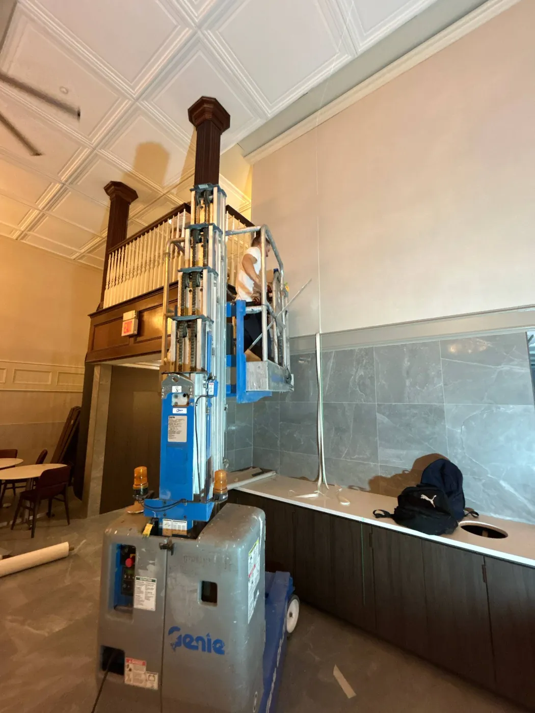 Personnel lift staged to wallpaper a double-height wall — wallpaper installation by ProKir Design