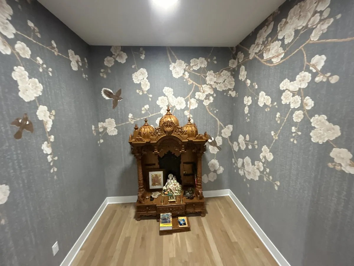 Chinoiserie hand-painted style cherry blossom mural behind ornate altar in luxury salon
