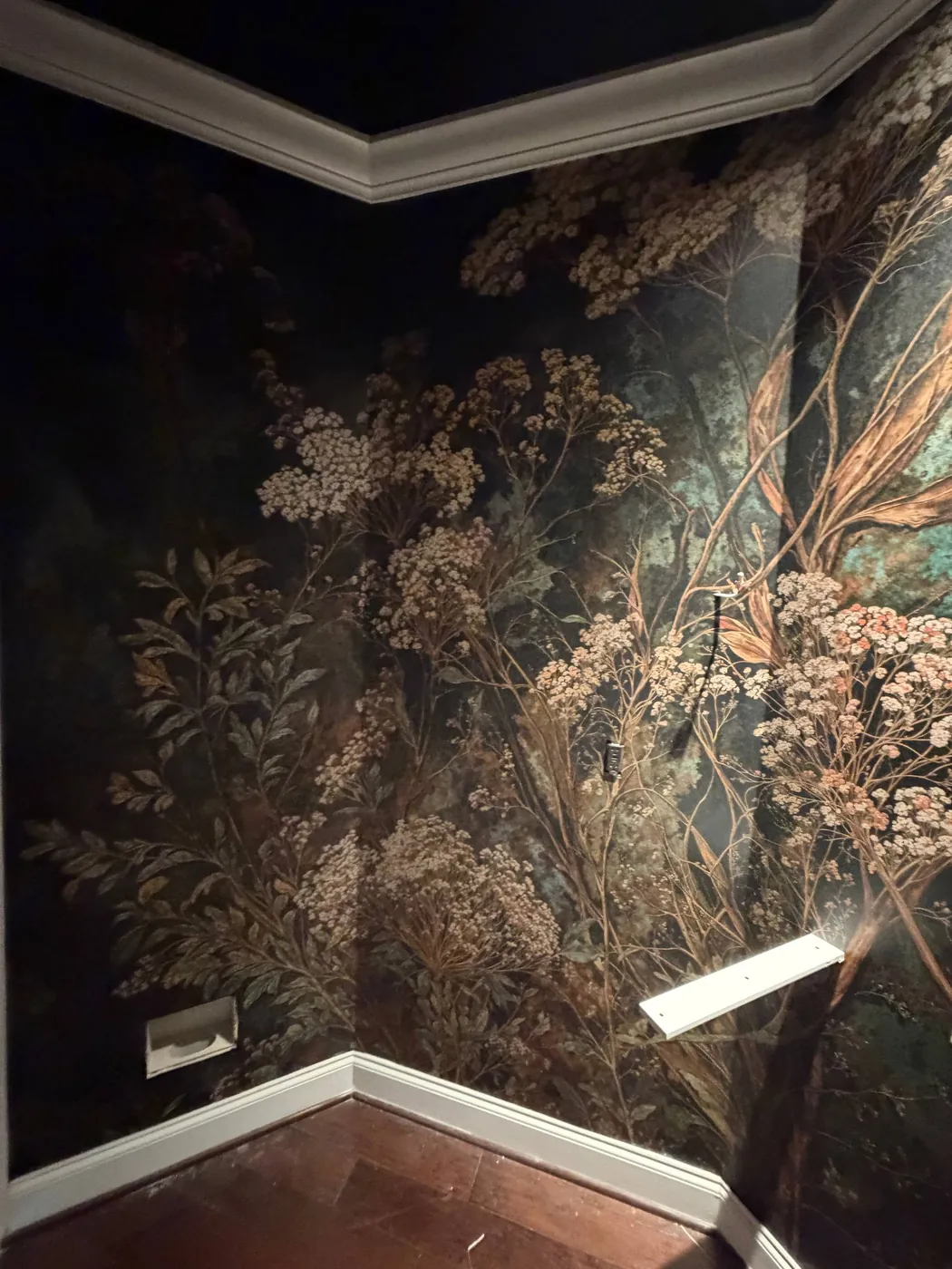 Dark botanical mural wrapping a powder room — wallpaper installation by ProKir Design