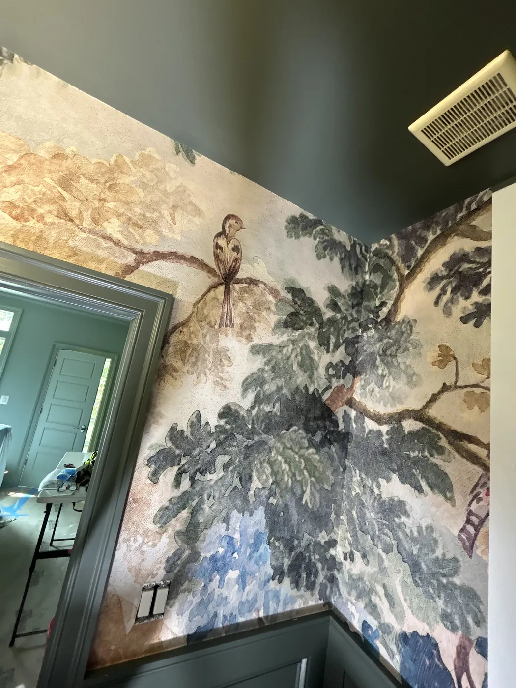 Tropical bird and foliage mural above dark wainscoting — wallpaper installation by ProKir Design
