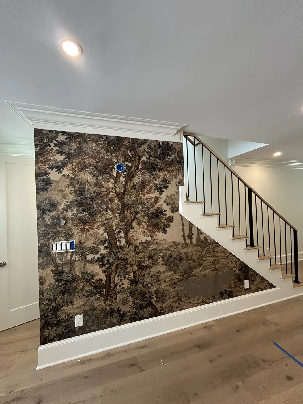 Tree mural running up beside a staircase — wallpaper installation by ProKir Design
