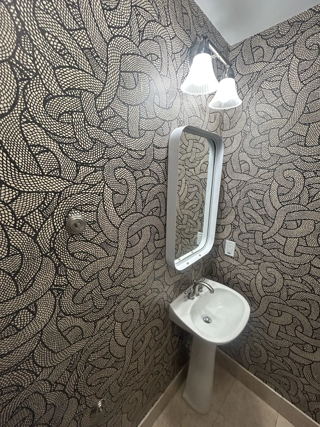 Black and white graphic knot wallpaper in a powder room — wallpaper installation by ProKir Design