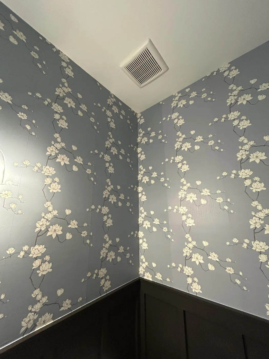 Blue blossom wallpaper above dark wainscoting — wallpaper installation by ProKir Design