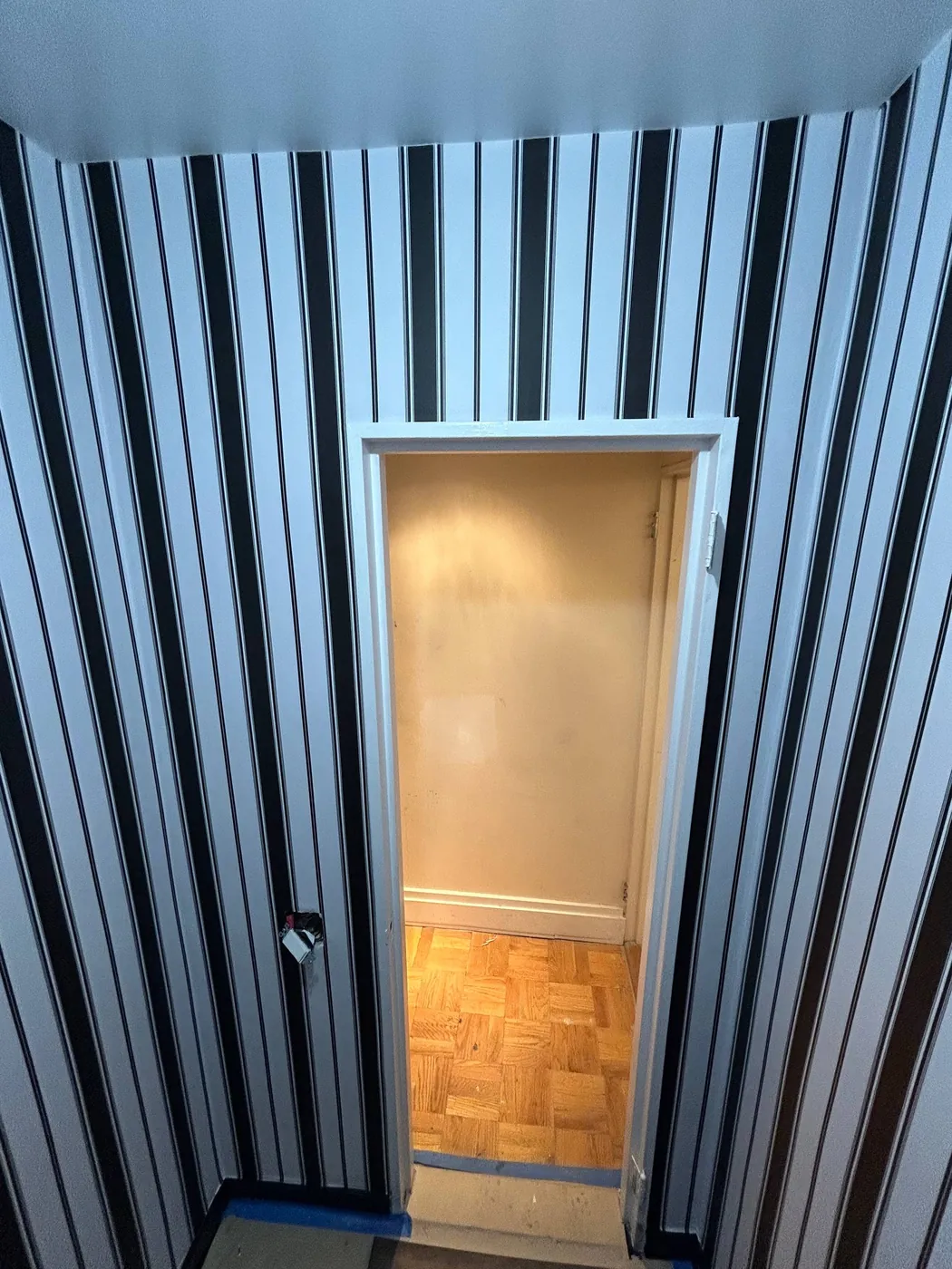 Black and white stripe wallpaper in a powder room — wallpaper installation by ProKir Design