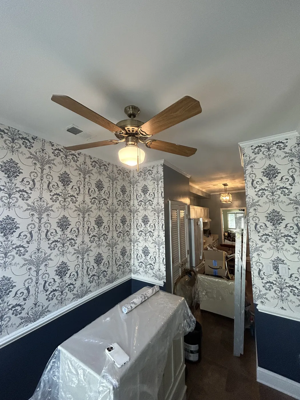 Blue toile wallpaper above navy wainscoting in a bathroom, New Jersey — wallpaper installation by ProKir Design