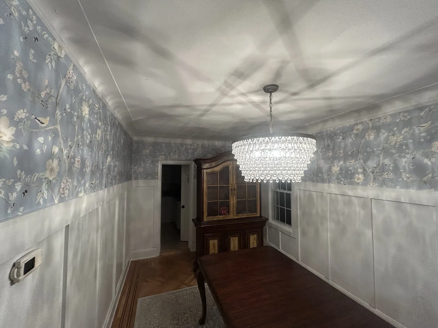 Blue floral wallpaper above white wainscoting in a dining room, Nassau County — wallpaper installation by ProKir Design