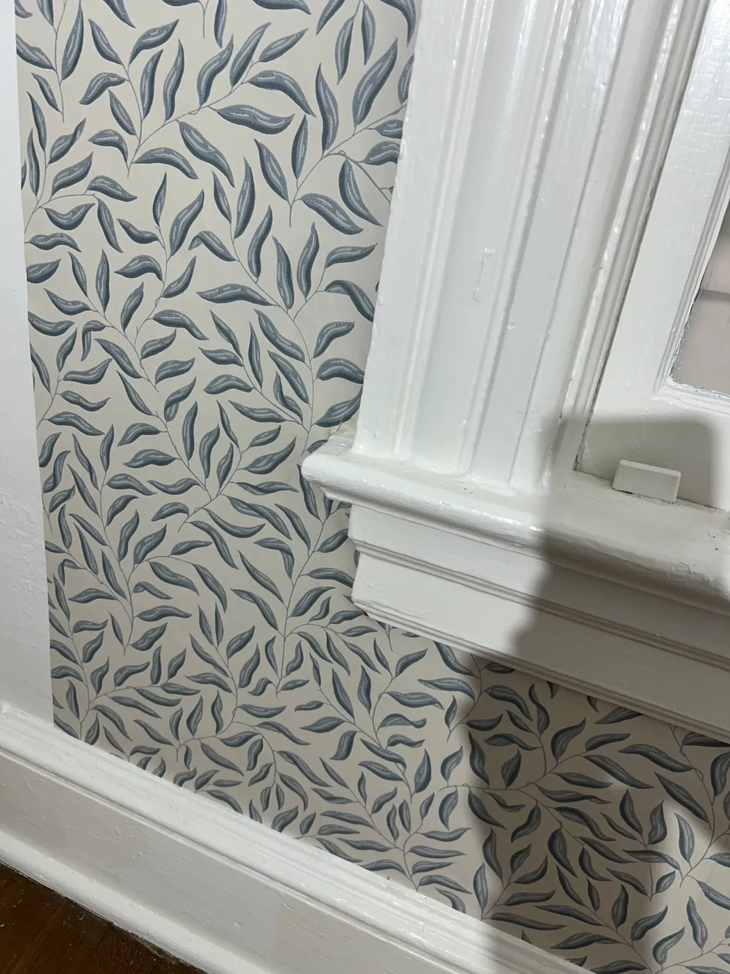 Leaf wallpaper trimmed tight around door molding — wallpaper installation by ProKir Design
