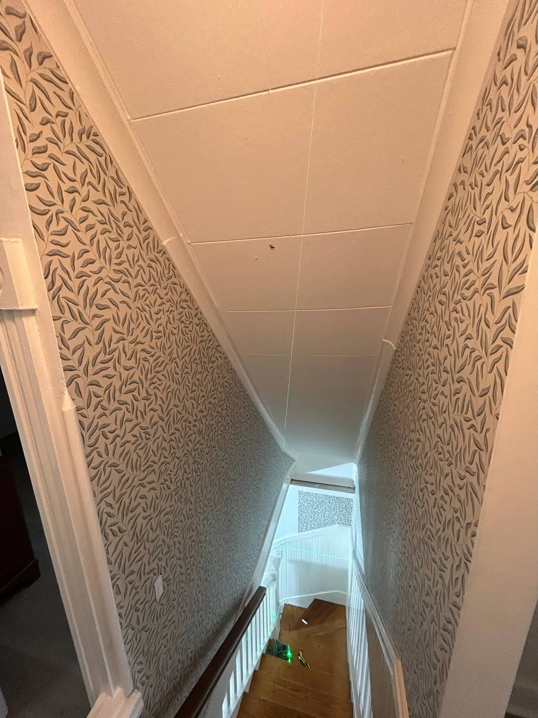 Leaf pattern wallpaper on a tall stairwell — wallpaper installation by ProKir Design