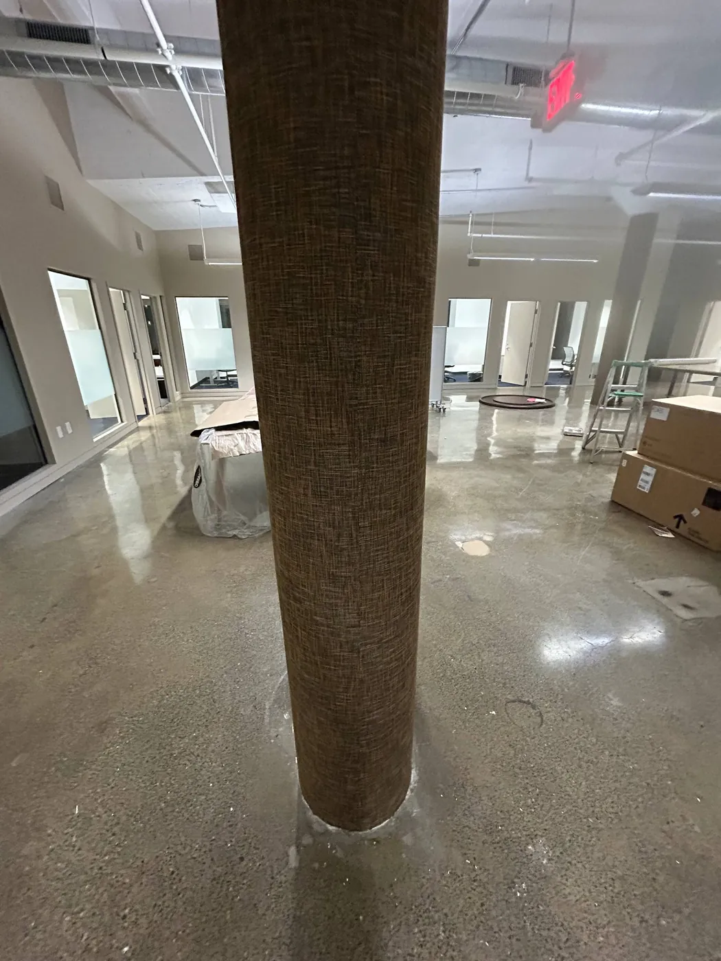 Grasscloth wrapped around a structural column in an open office — wallpaper installation by ProKir Design