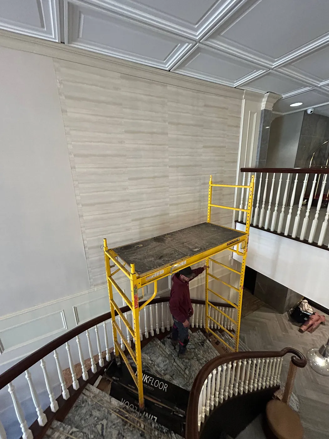 Scaffold staged over a staircase for tall wallpaper drops — wallpaper installation by ProKir Design