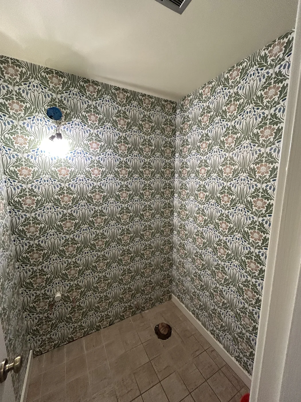 Green botanical lattice wallpaper in a tiled bathroom — wallpaper installation by ProKir Design