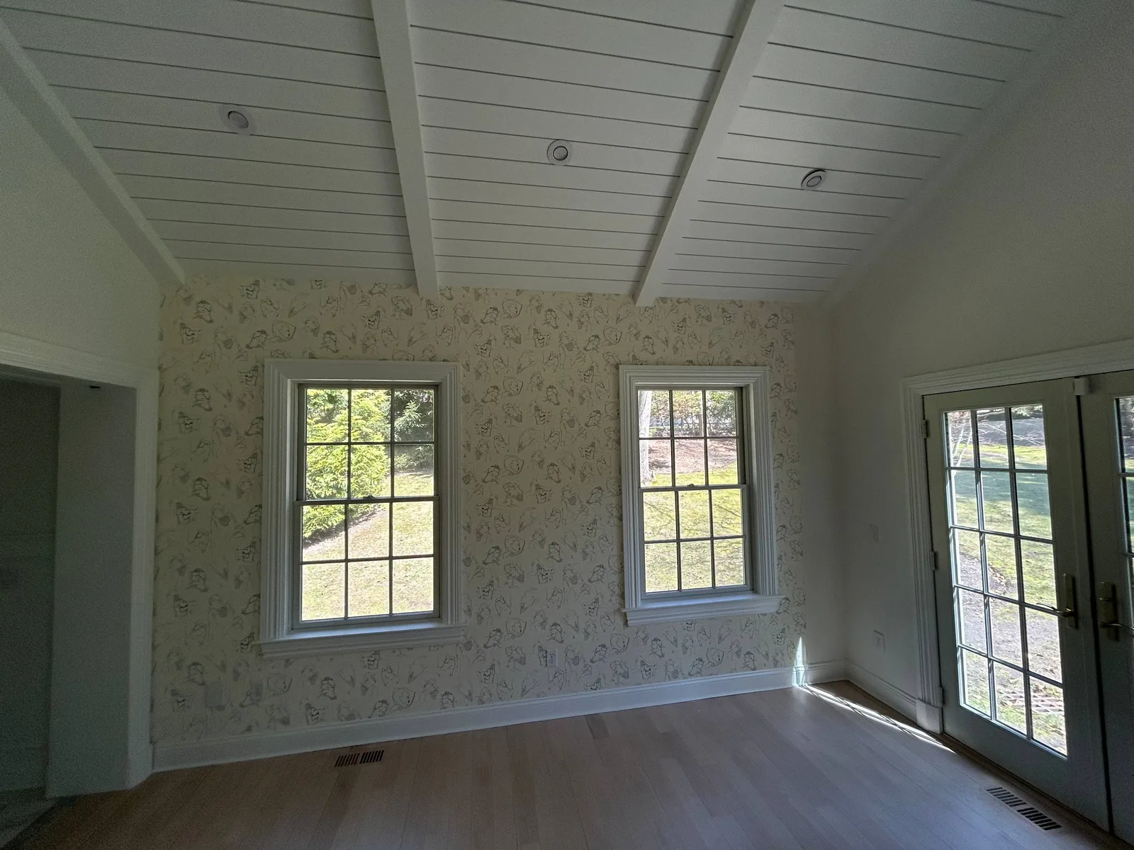 Southampton estate living pavilion with shiplap vaulted ceiling and botanical wallpaper