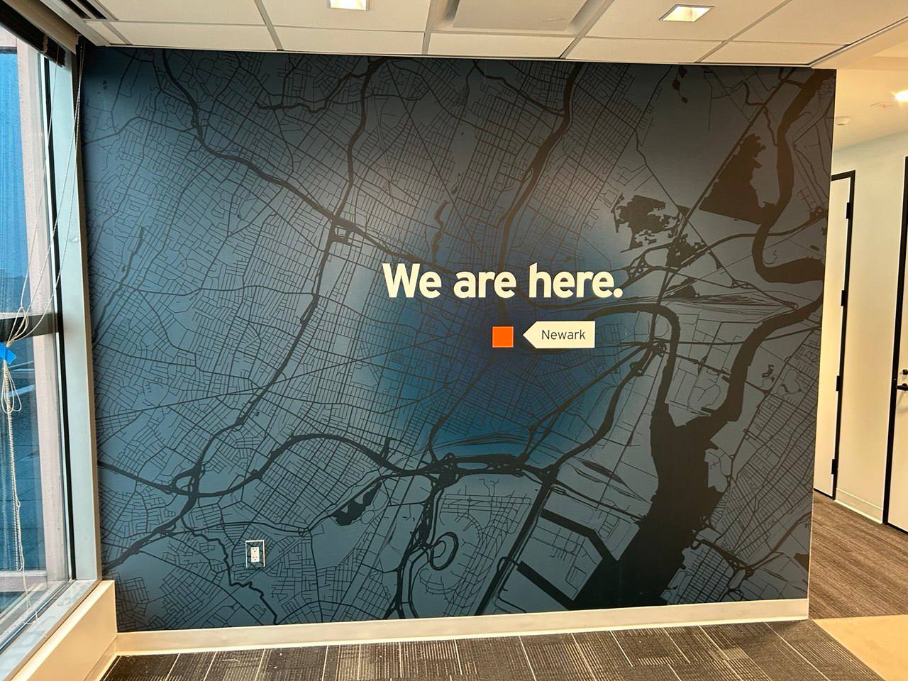 Commercial wallpaper installation — branded office wall map mural