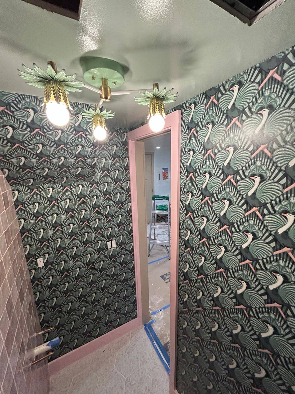 Green bird pattern wallpaper in bathroom with pink trim